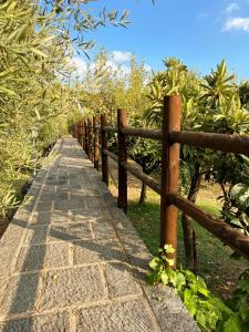 un camino de piedra junto a una valla de madera en Terre Villa Katia en Santa Maria di Licodia