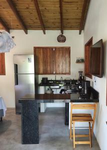 a kitchen with a large counter and a refrigerator at Acalanto do Sargi in Uruçuca