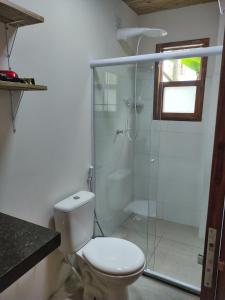 a bathroom with a toilet and a glass shower at Acalanto do Sargi in Uruçuca