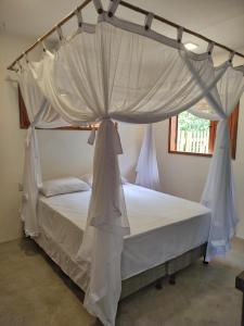 a bed with a canopy in a bedroom at Acalanto do Sargi in Uruçuca