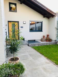 a house with a patio and a plant in front of it at Galerie Apartment Self-Check-In in Kolbermoor