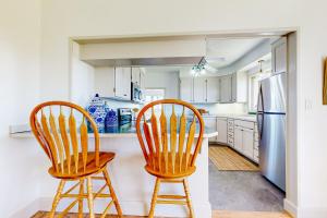 cocina con 2 sillas y nevera en The Farmhouse Cottage, en Burley