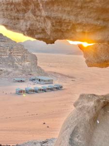 a view of a beach with a building in the desert at WADi RUM NOOR CAMP in Wadi Rum