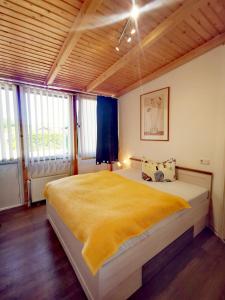 a bedroom with a large bed with a yellow blanket at Ferienwohnung life is life in Boltenhagen +35 photos