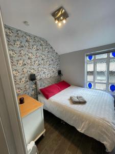 ein kleines Schlafzimmer mit einem Bett mit einem roten Kissen in der Unterkunft Parnell Place Apartments in Dublin