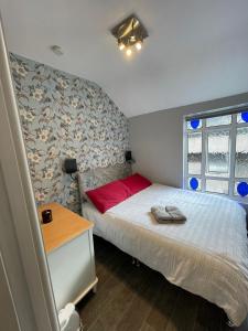 a small bedroom with a bed with a red pillow at Parnell Place Apartments in Dublin