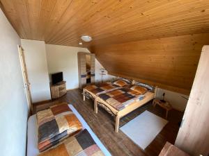 an attic bedroom with two beds and a wooden ceiling at Feriendomizil Marika in Kottenheim