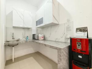 a kitchen with white cabinets and a red refrigerator at Villa Cisarua RJS in Brujul