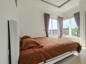 a white bedroom with a bed and a window at Villa Cisarua RJS in Brujul +24 photos