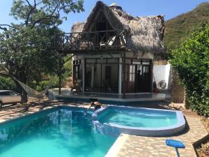a villa with a swimming pool in front of a house at Villa Coco in Taganga