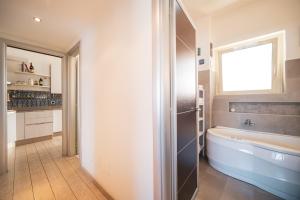 een badkamer met een bad, een wastafel en een raam bij Tiber House 60 Rome Marconi - Rome Vacation M&D in Rome +35 foto's