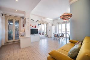 een woonkamer met een gele bank en een keuken bij Tiber House 60 Rome Marconi - Rome Vacation M&D in Rome