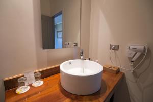 baño con lavabo blanco grande y espejo en Hotel Enjoy Pucon, en Pucón