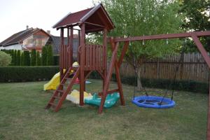 a wooden playground with a slide and a ladder at Prokop Vendégház in Tolcsva