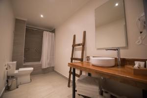uma casa de banho com um lavatório e um WC em Hotel Enjoy Pucon em Pucón