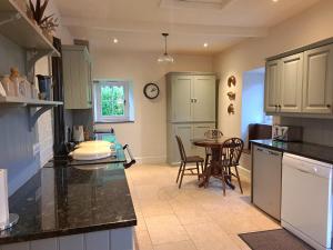 a kitchen with a table and a dining room at Countersett Hall in Askrigg