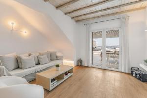 Mykonos Actor’s Villa. 2 BDRs, private mini-pool في مدينة ميكونوس: غرفة معيشة بيضاء مع أريكة وطاولة