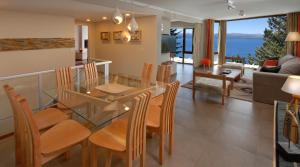 a dining room and living room with a glass table and chairs at Luxury Lake Views Apartments By Apartments Bariloche in San Carlos de Bariloche