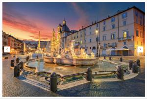 une fontaine au milieu d'une ville au coucher du soleil dans l'établissement Navona Stay, à Rome