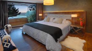 a bedroom with a large bed and a balcony at Luxury Lake Views Apartments By Apartments Bariloche in San Carlos de Bariloche