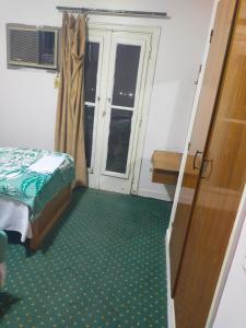 Cette petite chambre comprend un lit et une fenêtre. dans l'établissement Hotel minia, à Al-Minya