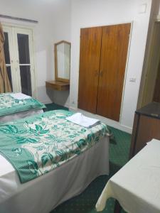 a bedroom with two beds and a dresser in it at Hotel minia in Al Minya