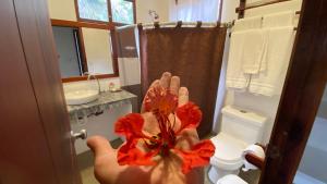 una persona che tiene a mano un fiore in bagno di Hosteria Guachapeli a Las Tunas