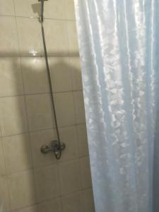 a shower with a white shower curtain and a shower at Hotel minia in Minya