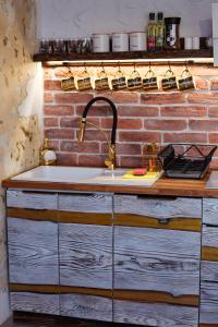 eine Küche mit Spüle und Ziegelwand in der Unterkunft PORANEK W GÓRACH in Ustrzyki Dolne
