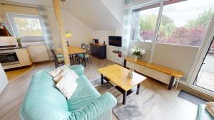 een woonkamer met een blauwe bank en een tafel bij NeuKlosterhof App. 26 in Pelzerhaken