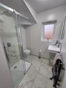 y baño con ducha y lavamanos. en Modern 3 bedroom home in Guildford. Sleeps 8, en Guildford