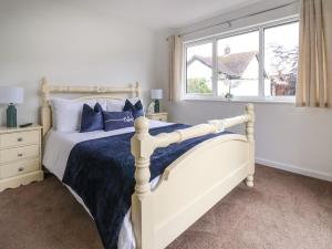 1 dormitorio con cama blanca y almohadas azules en Beach Retreat en Prestatyn