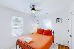 - une chambre avec un lit doté d'oreillers orange et d'un ventilateur de plafond dans l'établissement The Joyful Cottage, à Nashville