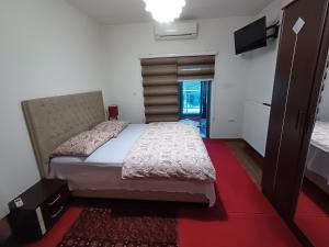 1 dormitorio con 1 cama grande y alfombra roja en Hollywood Motel, en Podlugovi