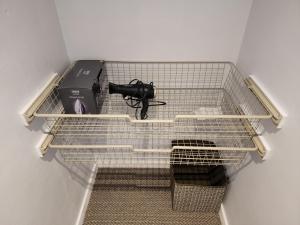 a wire shelf with a gun in a room at Modern 3 bedroom home in Guildford. Sleeps 8 in Guildford