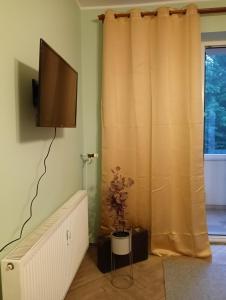 a living room with a television and a curtain at Niepodległości 859 in Sopot