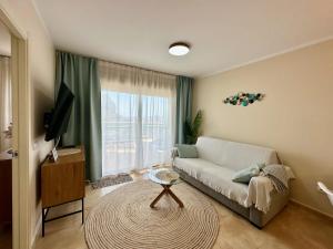 een woonkamer met een bank en een groot raam bij Esmeralda Suites 21º piso in Calpe