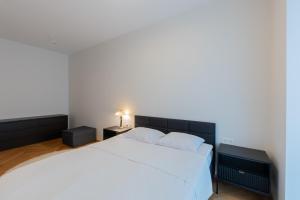 - une chambre avec un lit blanc et 2 tables de chevet dans l'établissement Cozy Stay Apartement, à Pärnu