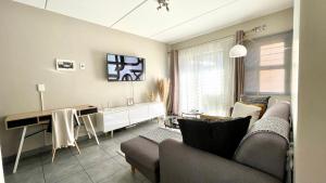 a living room with a couch and a table at Central and peaceful 2-bedroom Apt #ZonaHomes in Midrand