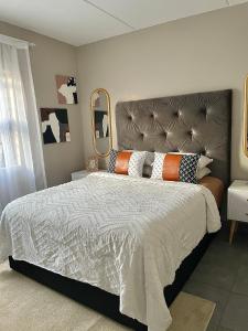 a bedroom with a large bed and a large mirror at Central and peaceful 2-bedroom Apt #ZonaHomes in Midrand