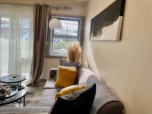 Central and peaceful 2-bedroom Apt #ZonaHomes في ميدراند: غرفة معيشة مع أريكة وطاولة