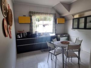 uma cozinha com uma mesa e cadeiras e um lavatório em Casa Gómez em São Lourenço
