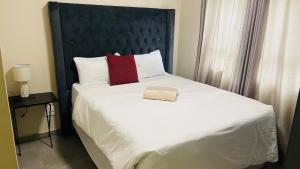 Un dormitorio con una cama grande con cabecero negro. en Mall Of Africa Spot2 By Damo, en Midrand