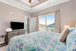 a bedroom with a bed and a flat screen tv at Glimmering Shell Hideaway in Holden Beach
