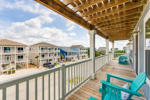 a deck with chairs and a view of the beach at Glimmering Shell Hideaway in Holden Beach