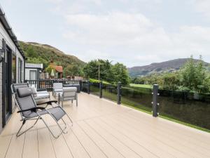 a deck with chairs and a view of the mountains at Robin Lodge in Crieff