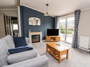 a living room with a couch and a tv at Robin Lodge in Crieff