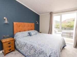 1 dormitorio con cama y ventana grande en Robin Lodge, en Crieff