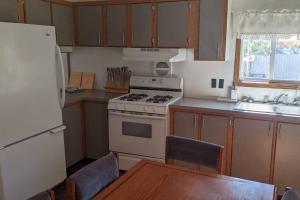 a kitchen with a stove and a refrigerator and a table at Lake Mac Retreat, boating, fishing hunting. in Lewellen