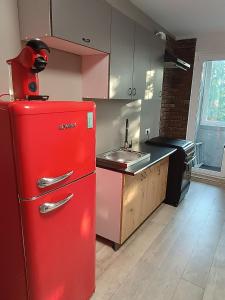 a red refrigerator in a kitchen with a sink at Lovely Stay in Siauliai in Šiauliai